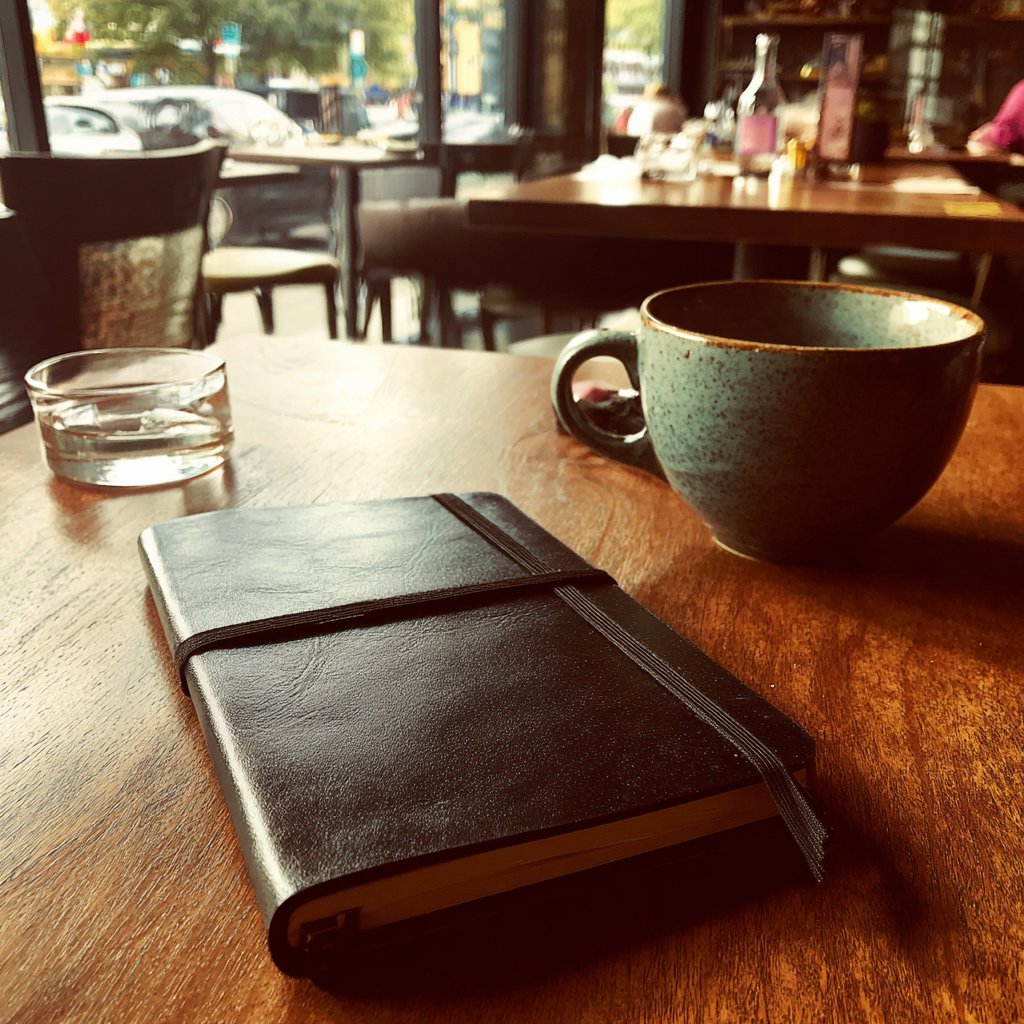 A black notebook on a table | Source: Midjourney