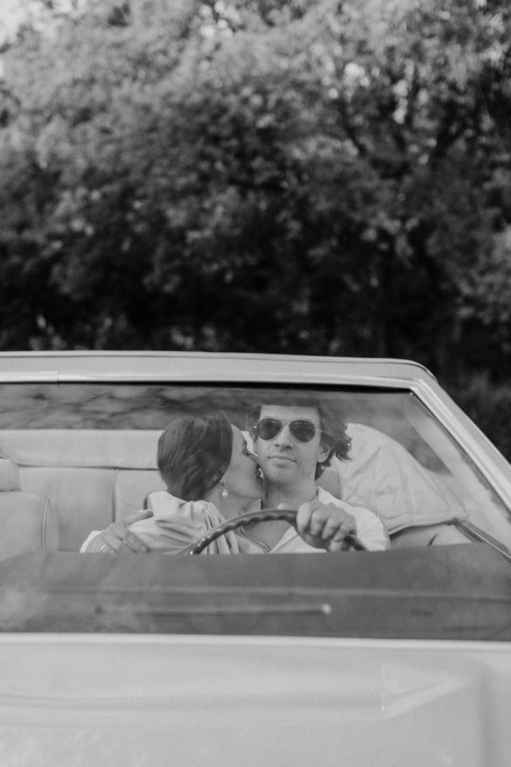 A man driving while a woman kisses him | Source: Pexels