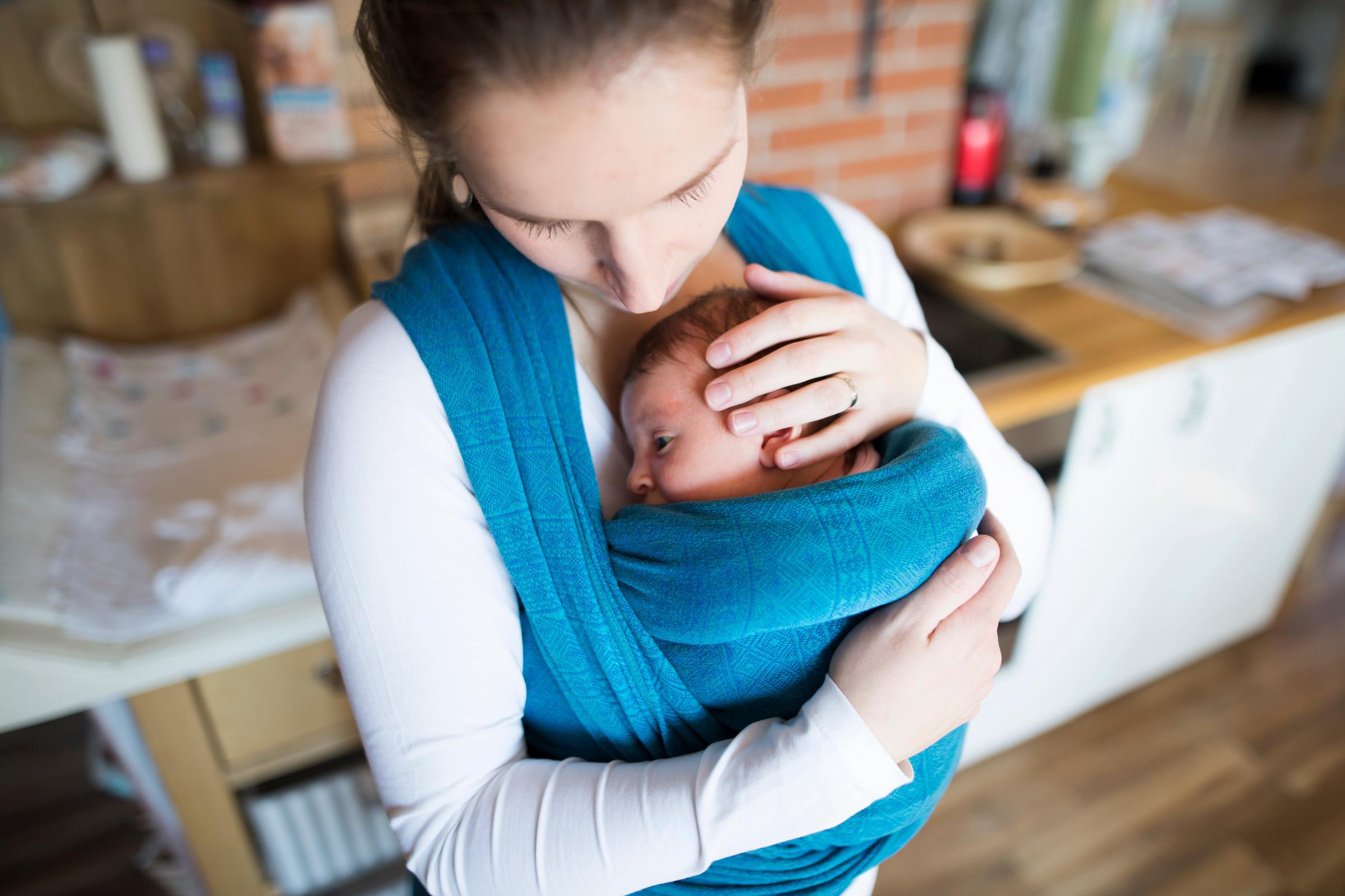Mother carrying her newborn | Source: Shutterstock