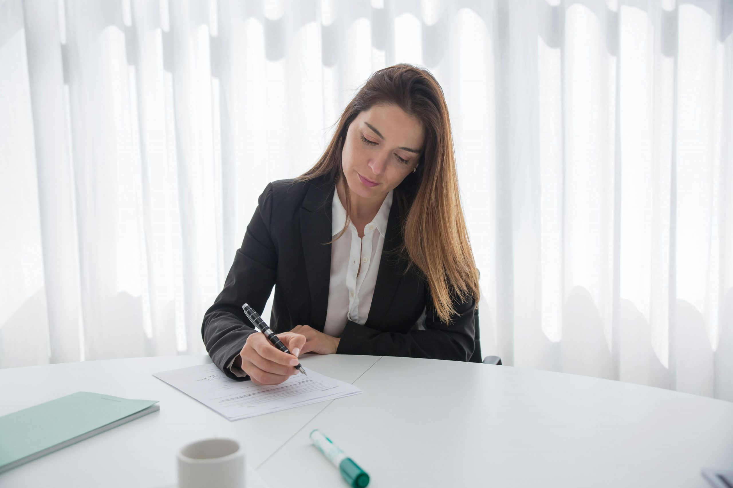 Woman signing documents | Source: Pexels