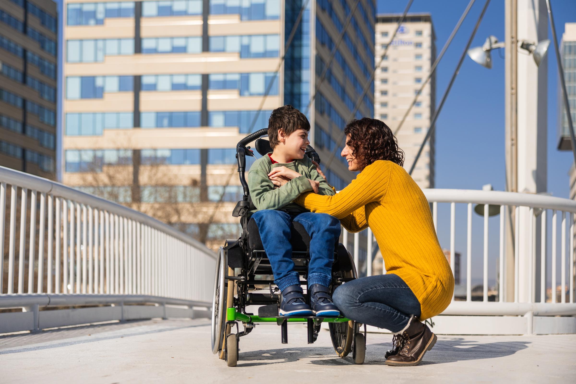 A woman sitting beside her son in a wheelchair | Source: Shutterstock