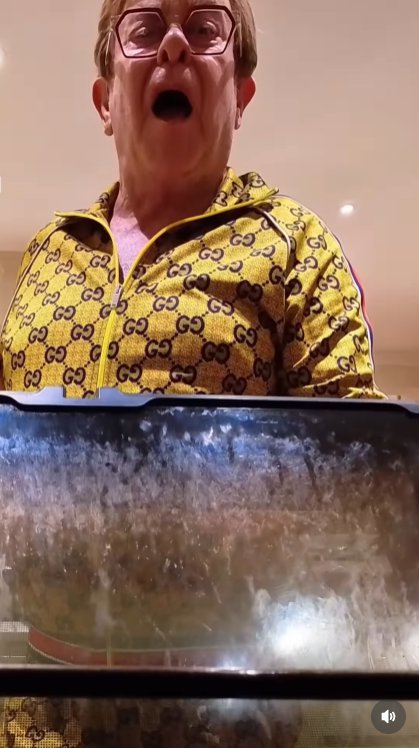 Peering into the oven as the song blares yet again, John lets out a terrified scream — the final straw in his battle against a kitchen that won't stop singing back at him. | Source: Instagram/eltonjohn
