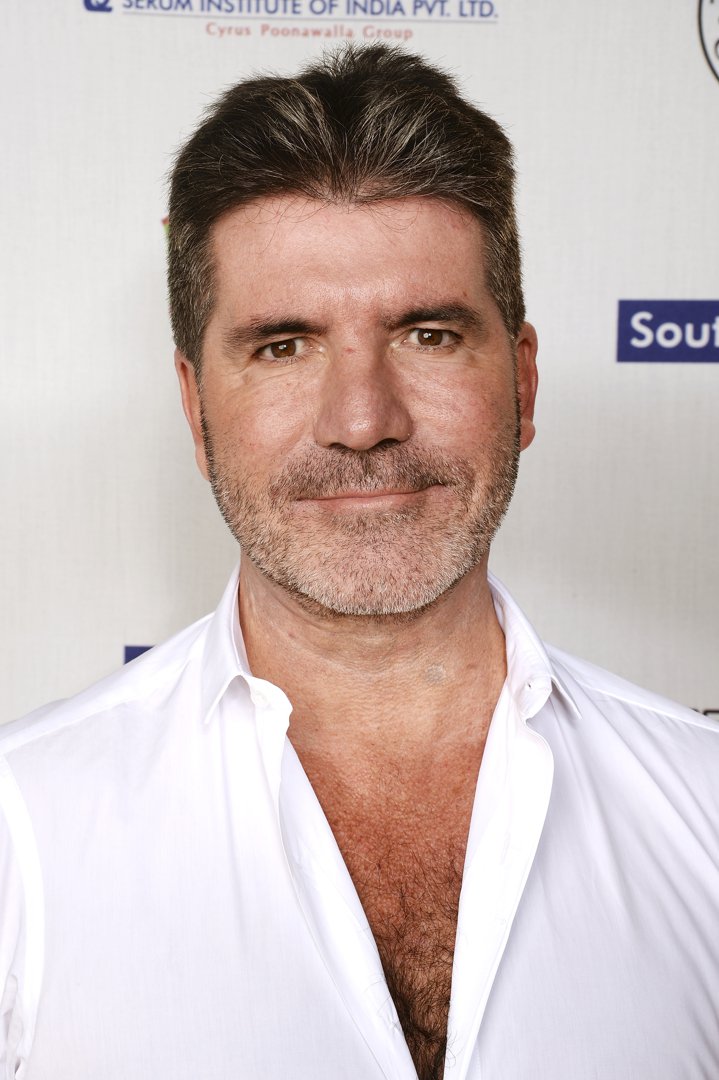 Effortlessly blending elegance and ease, Cowell dons an open-collared white shirt at the British Asian Trust event in 2016. Inside London's Natural History Museum, he balances informal charm with old-world grandeur.