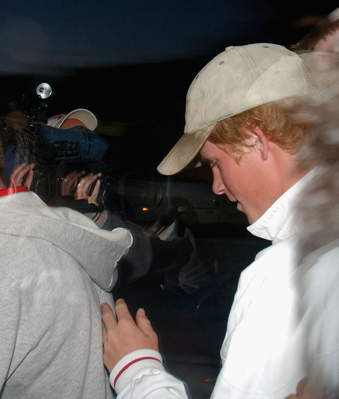 With his head down and cap pulled low, Prince Harry arrived at Subiaco Oval in Perth, Australia, on October 18, 2003, ahead of England's Rugby World Cup match against South Africa. Navigating a crowd of photographers, the 19-year-old prince appeared quietly focused — a contrast to the electric atmosphere of the stadium and the growing public fascination with his every move.