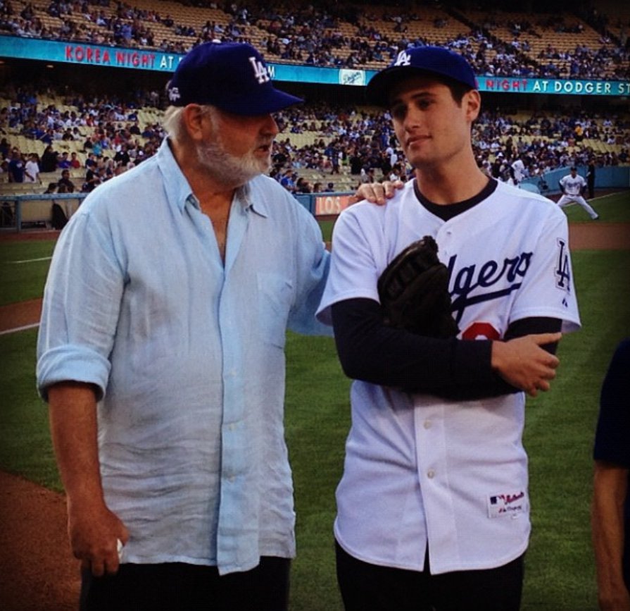 Rob and Jake Reiner stand on a baseball field at a packed stadium, from a post dated August 5, 2012. | Source: Instagram/jakereiner