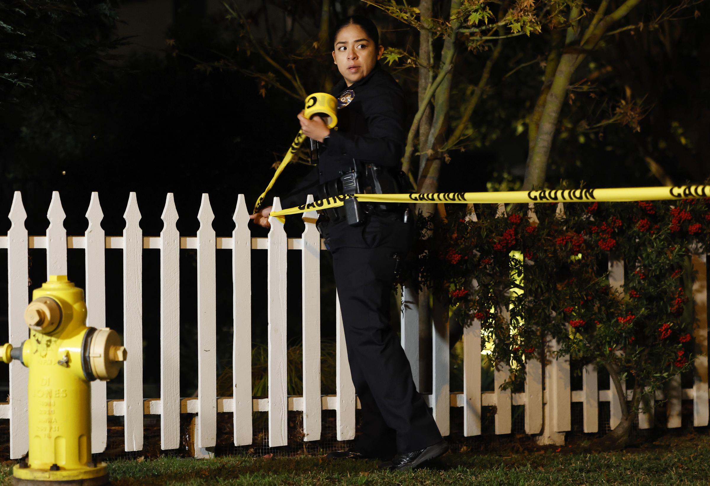 An LAPD officer secures the scene with crime scene tape outside the Brentwood home of Rob and Michele Singer Reiner on December 14, 2025 | Source: Getty Images