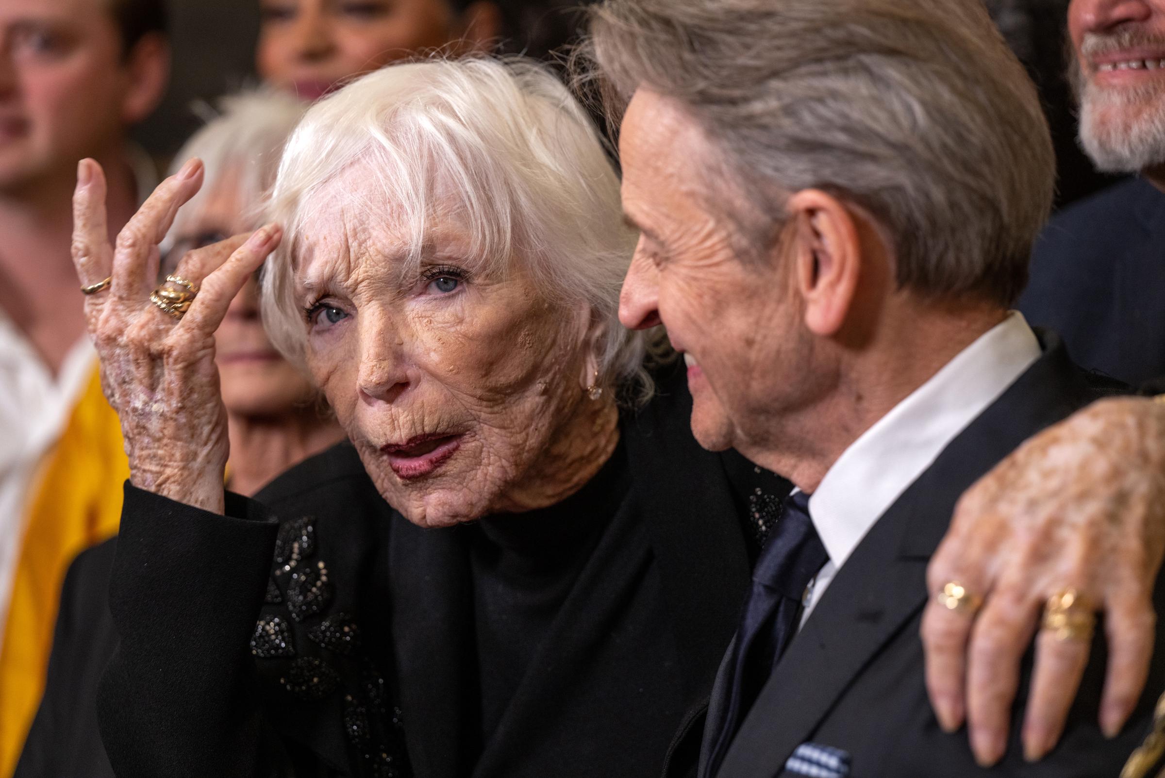 A candid embrace between icons &mdash; MacLaine shares a spirited exchange with Mikhail Baryshnikov at the 2025 Dance Hall of Fame Ceremony. Animated and affectionate, the Oscar winner captures the heart of a moment brimming with mutual respect and deep artistic connection.