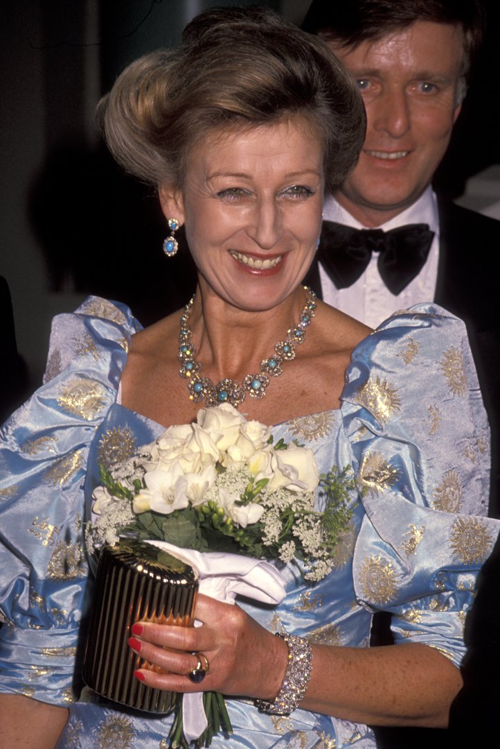 Shining under California lights, Princess Alexandra attends the 1990 BAFTA Gala honouring Sir Michael Caine. Carrying a small bouquet and dressed in a gold-detailed gown, she smiles for cameras &mdash; a royal touch of elegance at a star-studded celebration.