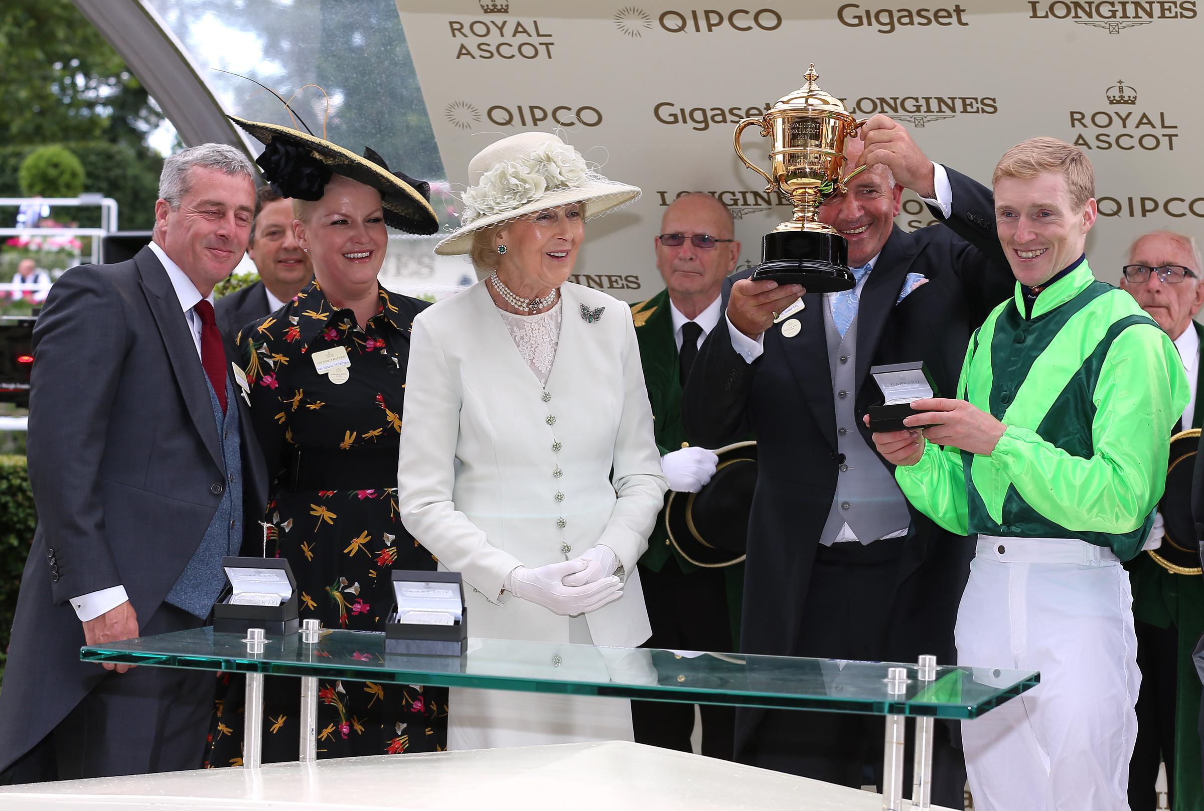 Princess Alexandra beams as she presents the Royal Hunt Cup at Ascot on 20 June 2018. Dressed in crisp white with a wide-brimmed hat, she shares the winning moment with jockey William Lee &mdash; a cherished highlight of the British social calendar.
