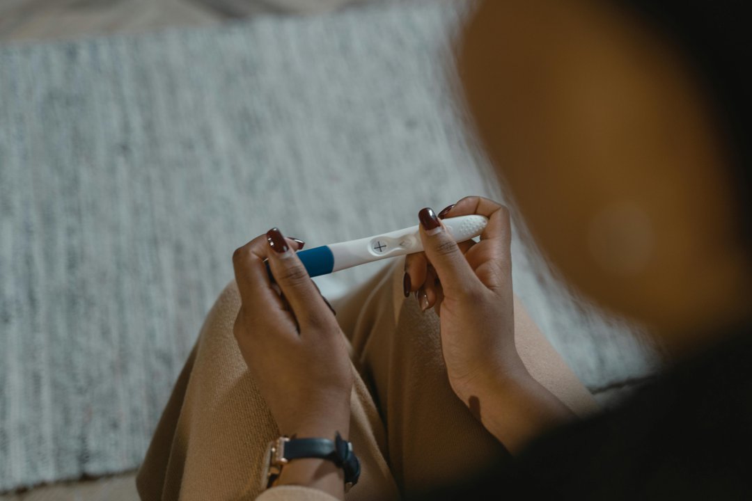 A woman holding a pregnancy test | Source: Pexels