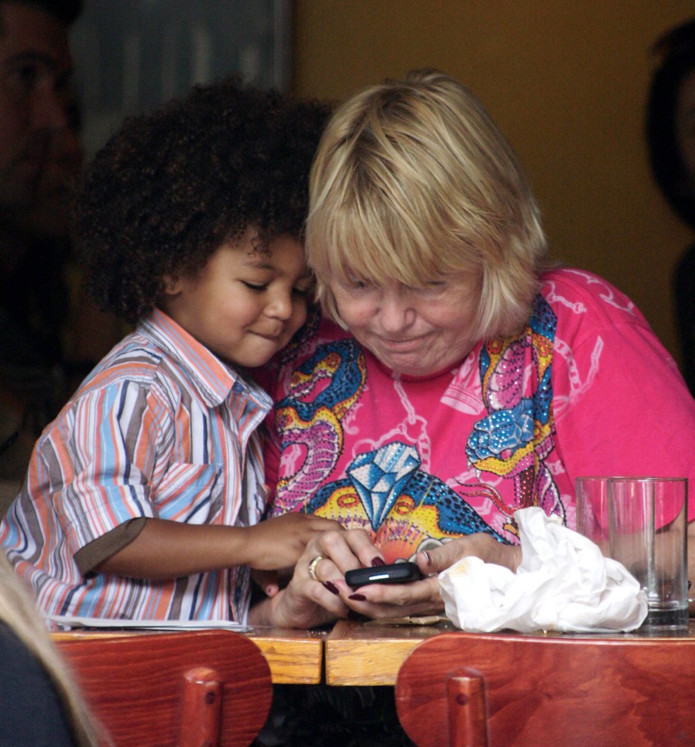 Johan Samuel sits close to his grandmother, Erna Klum, as they look at a phone together during lunch in New York City on June 17, 2009 | Source: Getty Images