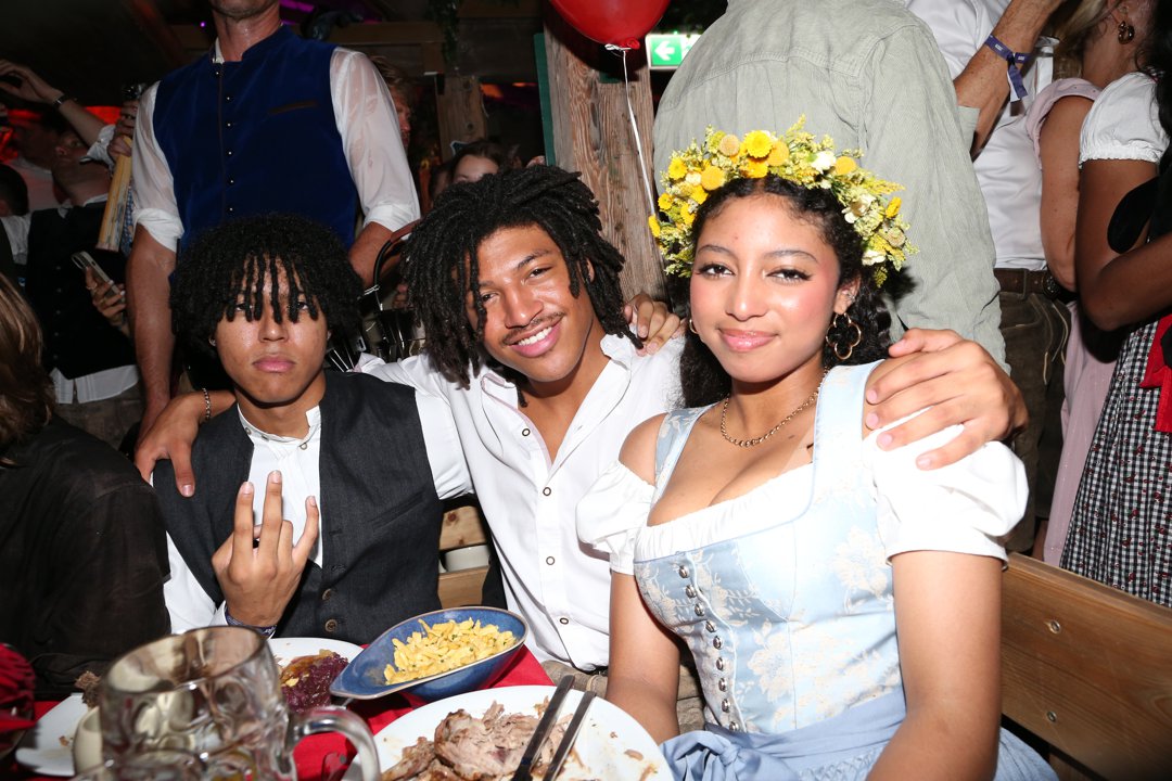 Johan, Henry, and Lou Samuel sit side by side at Oktoberfest in Munich, Germany, on September 20, 2025 | Source: Getty Images