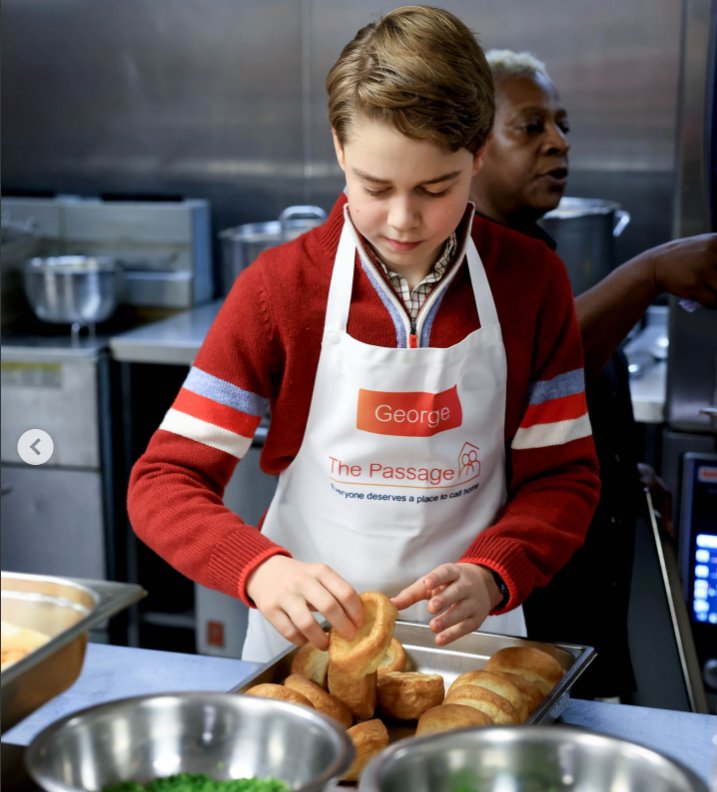 Prince George carefully stacks pastries while volunteering in the kitchen at The Passage, wearing an apron with his name badge visible. |Source: Instagram/princeandprincessofwales