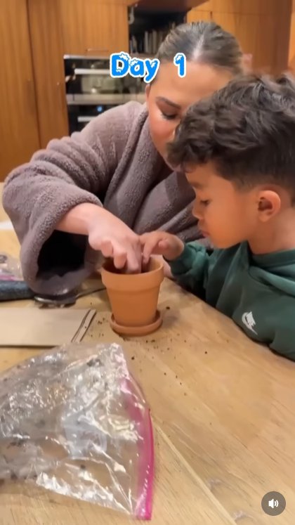 Planting the Magic: Still Day 1, and Teigen leans in close, guiding little hands as candy cane 