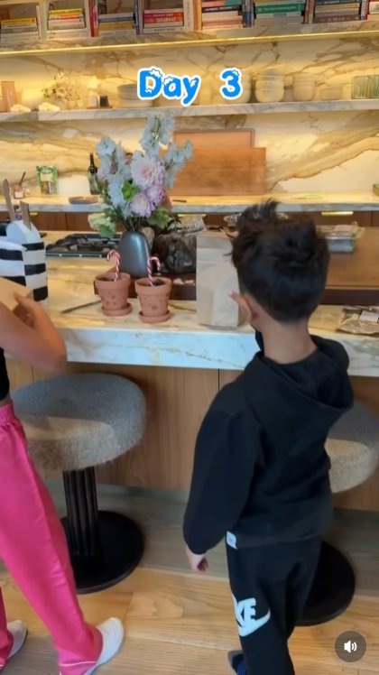 Bigger Canes, Bigger Reactions: Day 3 brings even taller candy canes &mdash; and even wider eyes &mdash; as the kids gather in awe around the kitchen counter. The festive plants are 