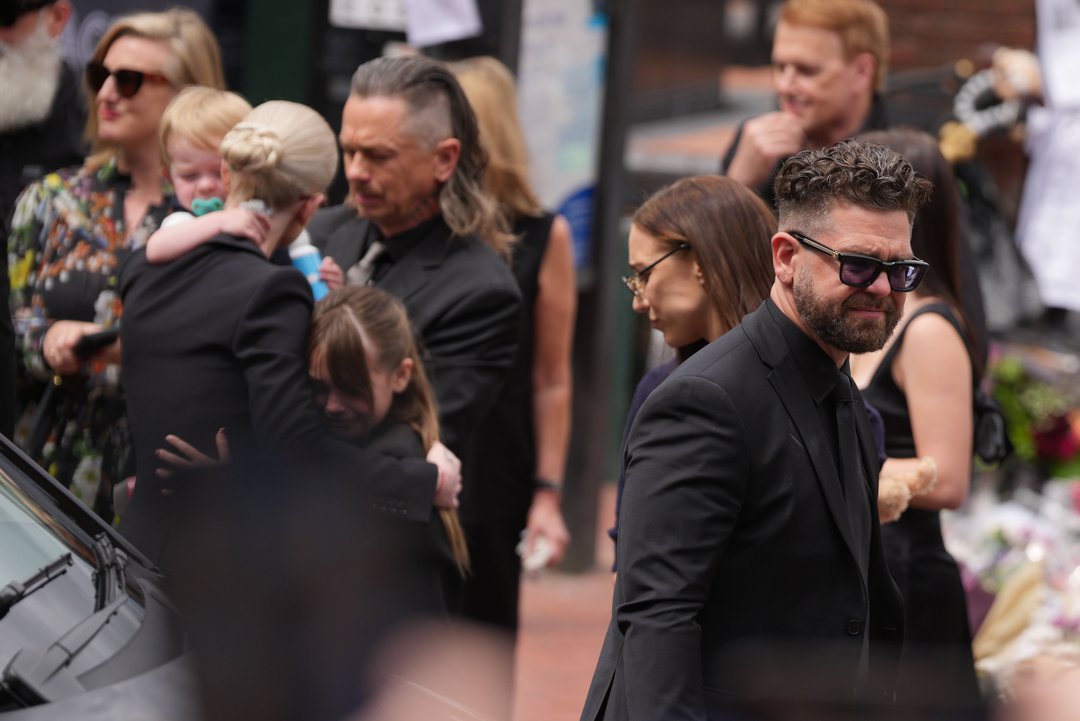 Jack Osbourne and family members stopped to view tributes to the late Ozzy Osbourne from fans at Black Sabbath Bench and Bridge as his funeral cortege travelled through his home city of Birmingham on July 30, 2025, in England. | Source: Getty Images