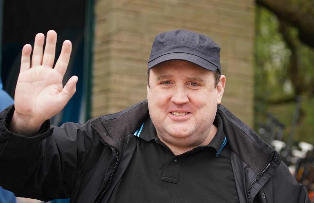 Seen waving to fans outside the Anderton Centre in April 2022, Peter Kay looked noticeably heavier, with a round face and fuller frame under a loose-fitting black jacket and cap. The rare public sighting came after years away from the spotlight, capturing the comedian in casual attire and offering a glimpse into his pre-transformation appearance.
