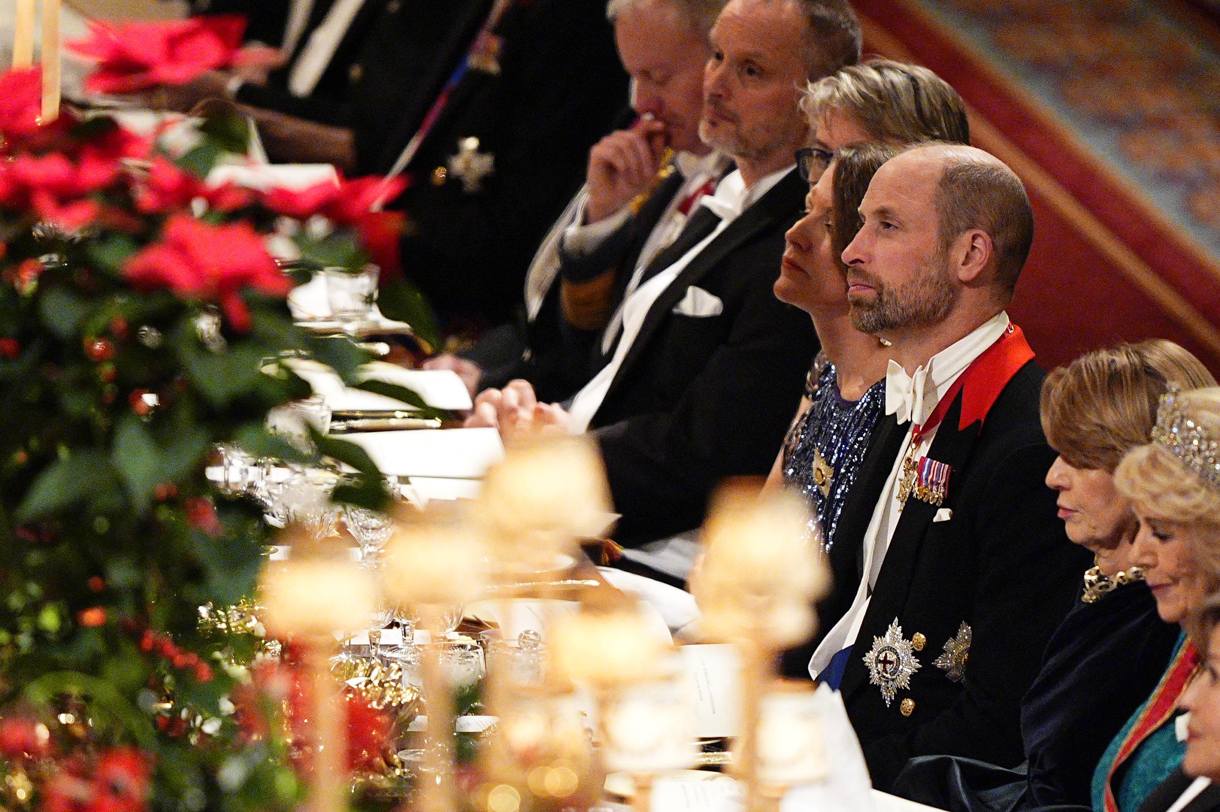 William, Prince of Wales, was seated alongside Germany's First Lady, Elke Büdenbender, and Queen Camilla during the state banquet at Windsor Castle on December 3, 2025. Surrounded by diplomatic guests, poinsettia arrangements, and golden candlelight, the prince listened attentively as formal speeches marked the significance of the German state visit to the United Kingdom.
