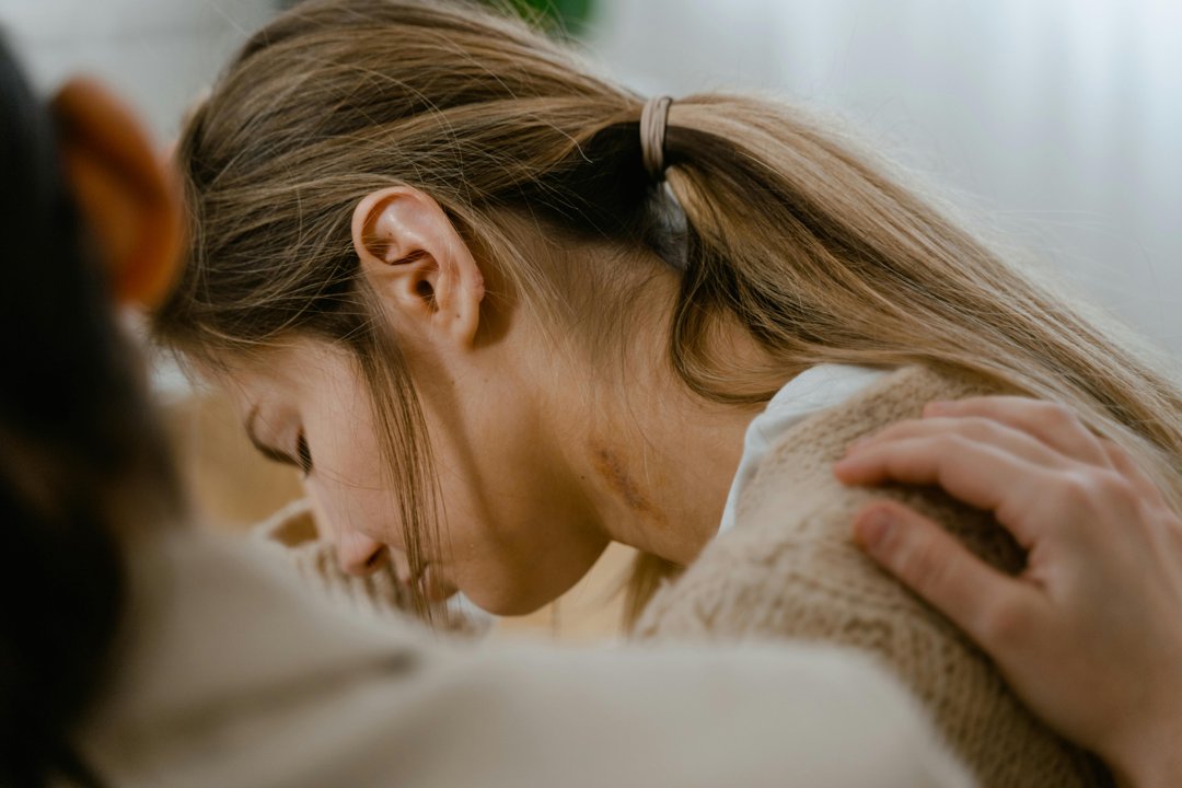 Emotional woman crying with a hand on her shoulder | Source: Pexels