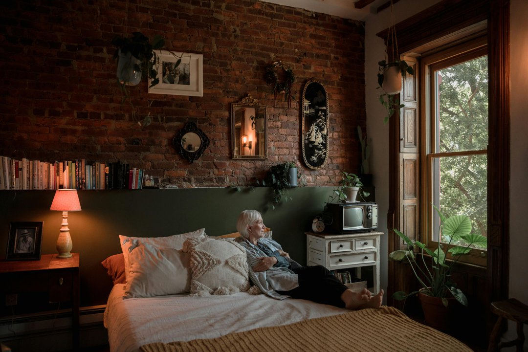Elderly woman sitting on bed | Source: Pexels