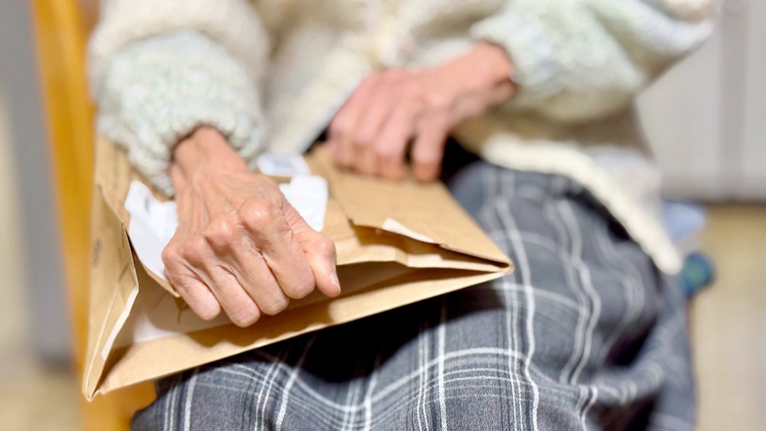Hands of an elderly woman holding an envelope | Source: Shutterstock
