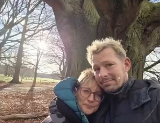 Katy and Adam Rickitt pictured embracing beneath a tree at Tatton Park after scattering their dog Daphne's ashes — from a post dated January 4, 2026. | Source: Instagram/katyrickitt