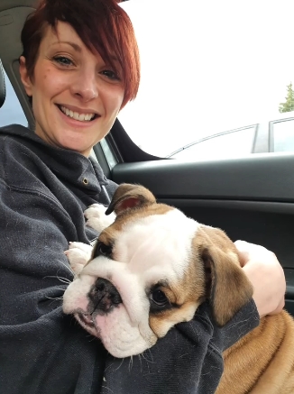 Katy Rickitt smiling in the car as she cuddles a puppy Daphne — from a post dated December 8, 2025. | Source: Instagram/katyrickitt