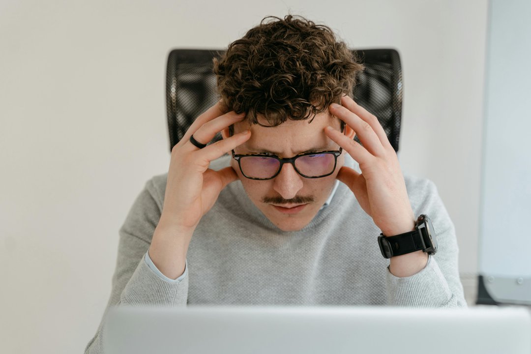A stressed man looking at a laptop | Source: Pexels