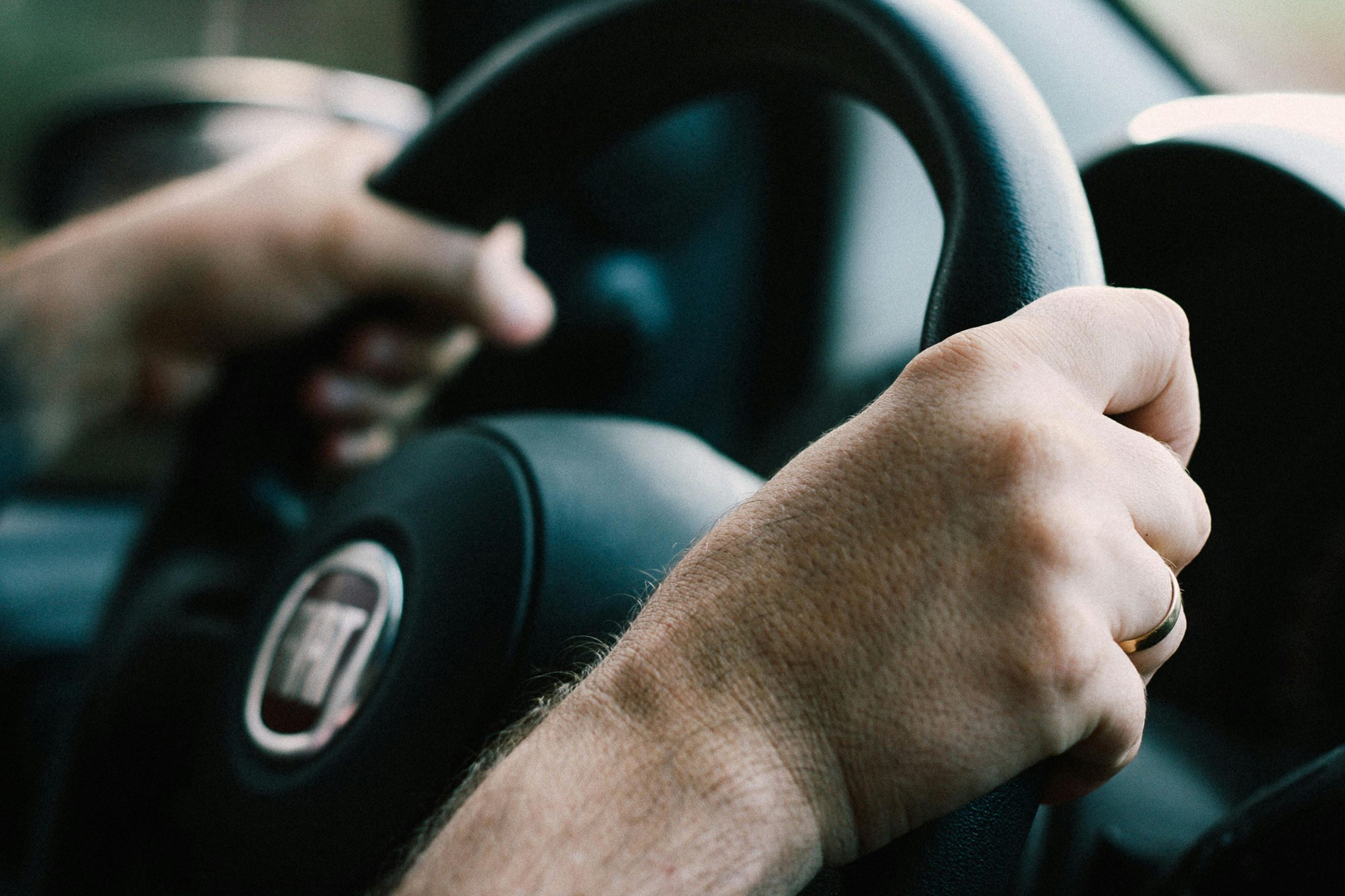 A man's hands on a steering wheel | Source: Pexels