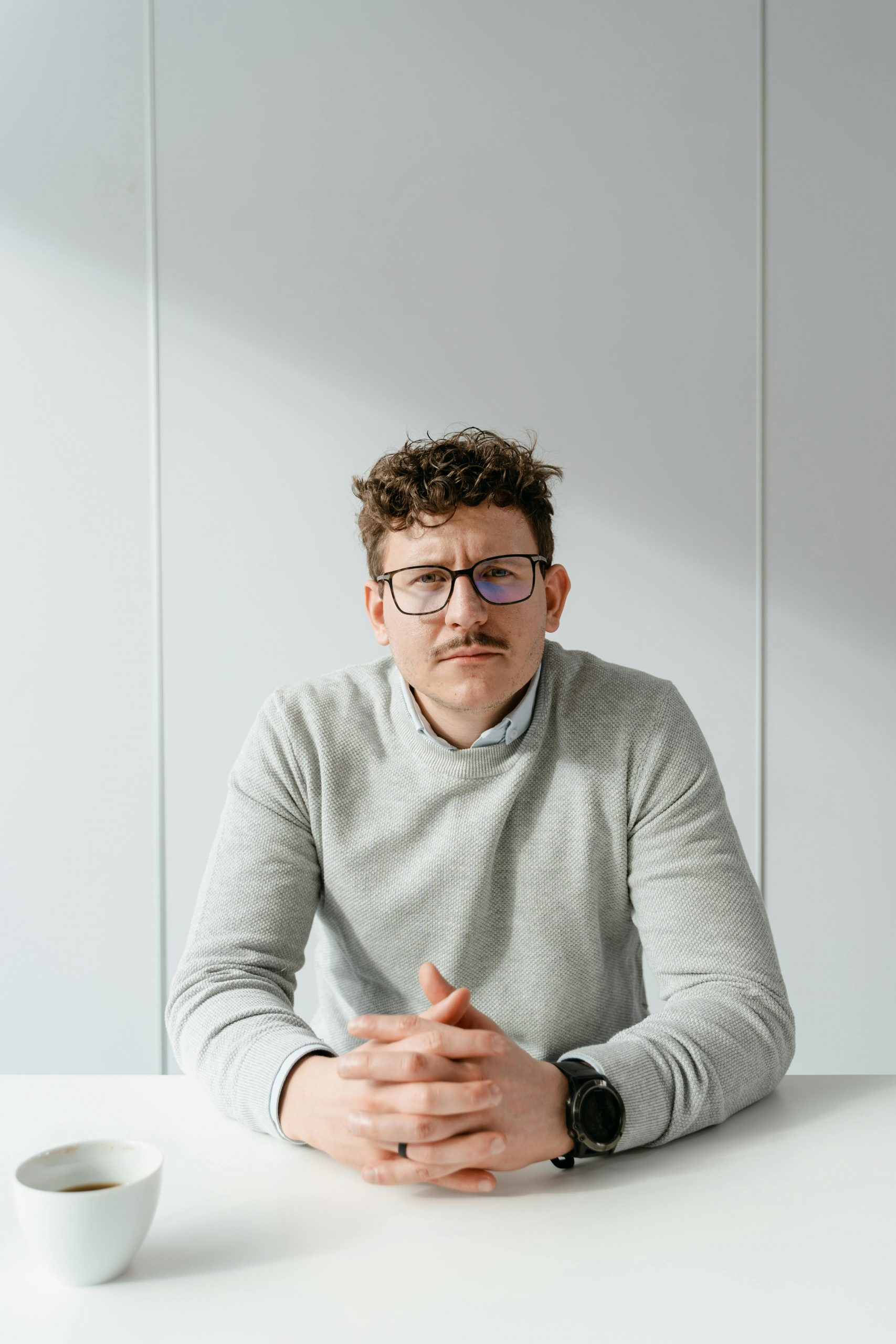 A serious man sitting at a table | Source: Pexels