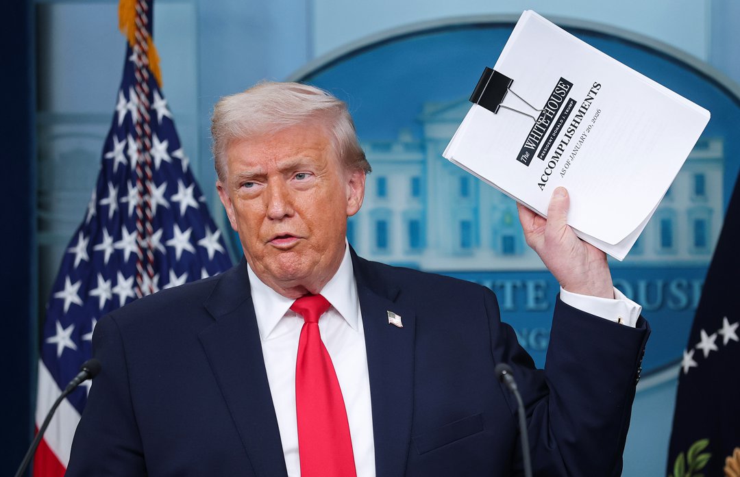 U.S. President Donald Trump displays a stack of papers labeled