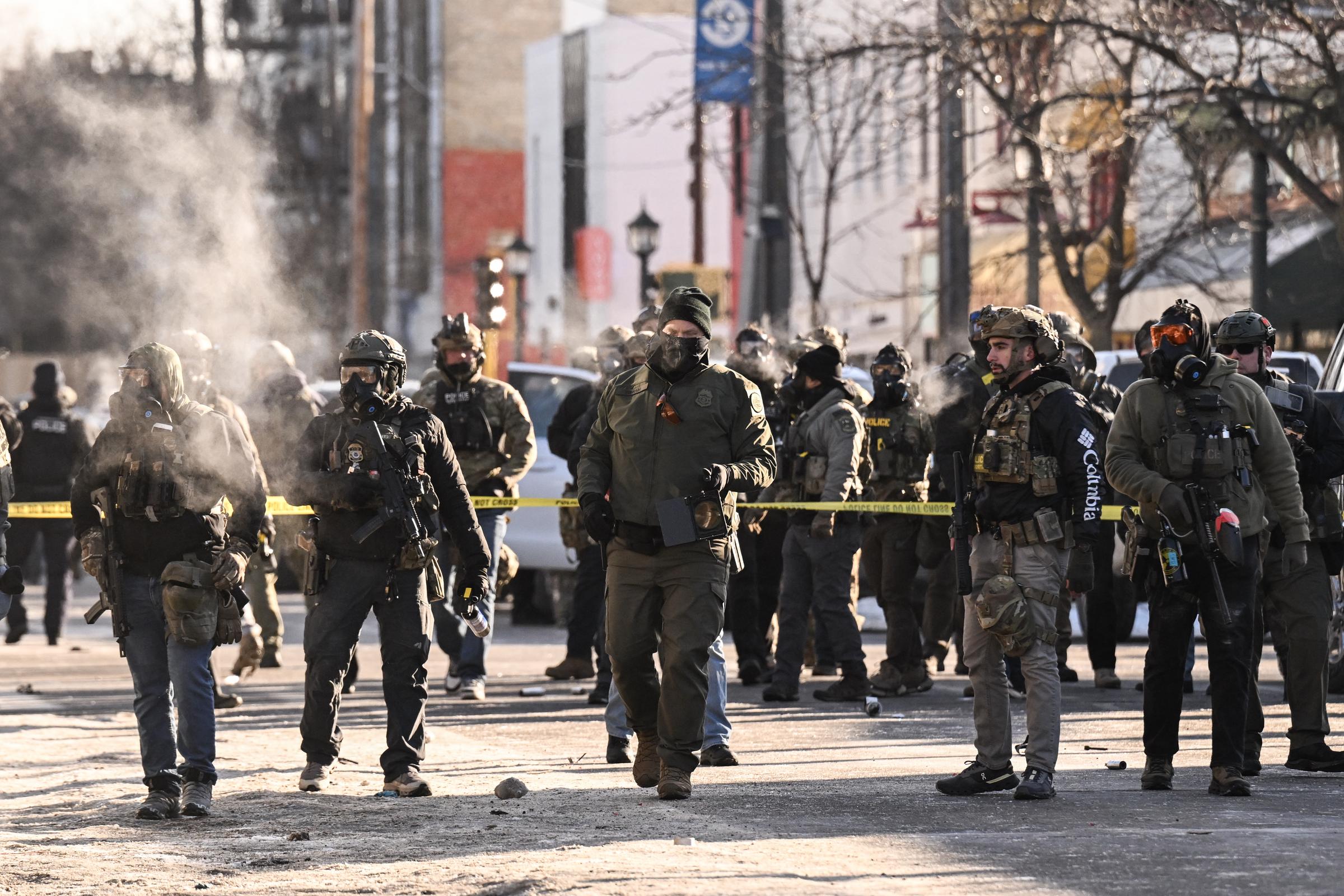 Federal agents stand behind police tape near the site of a shooting during an immigration enforcement operation in Minneapolis on January 24, 2026 | Source: Getty Images