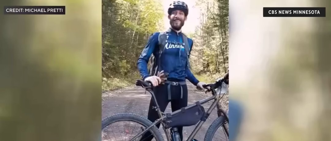 Alex Jeffrey Pretti smiles during a biking trip through the woods, wearing cycling gear and a blue jersey | Source: YouTube/CBS News Minnesota