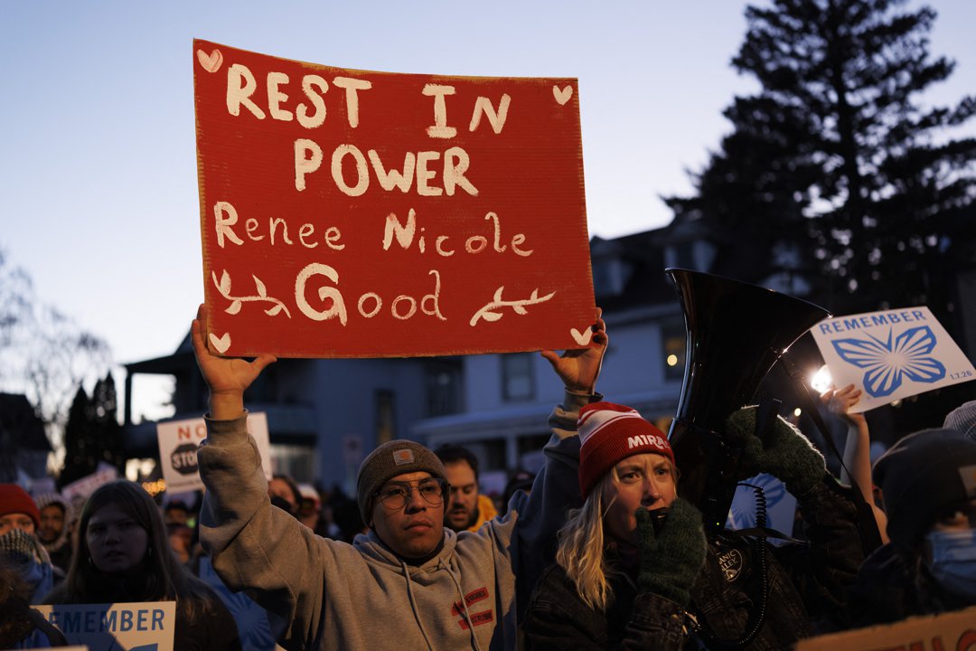 People attend a vigil in Minneapolis holding signs honoring Renee Nicole Good after she was fatally shot by an ICE agent | Source: Getty Images