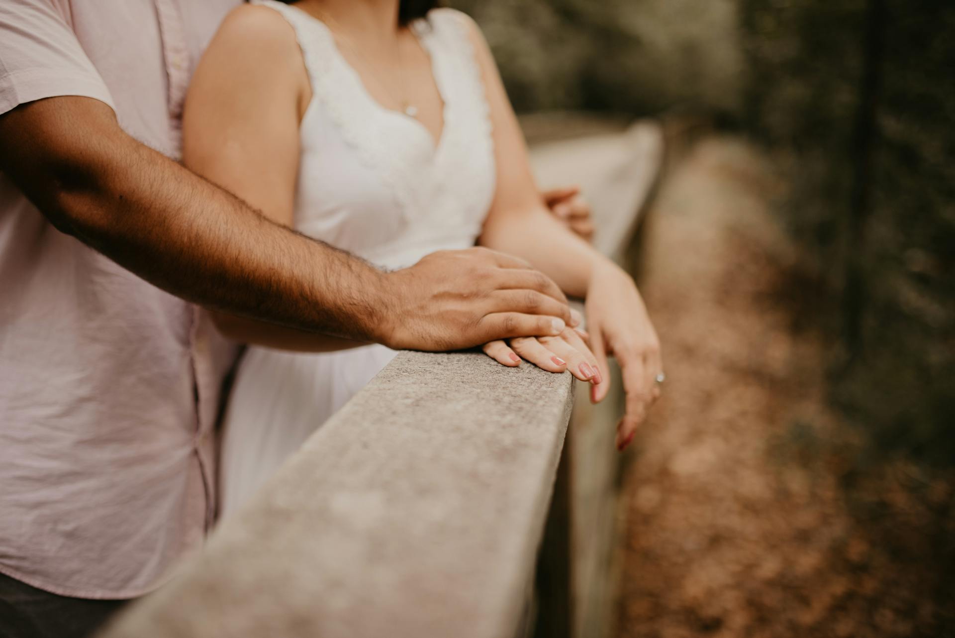 A couple hugging on a wooden bridge | Source: Pexels