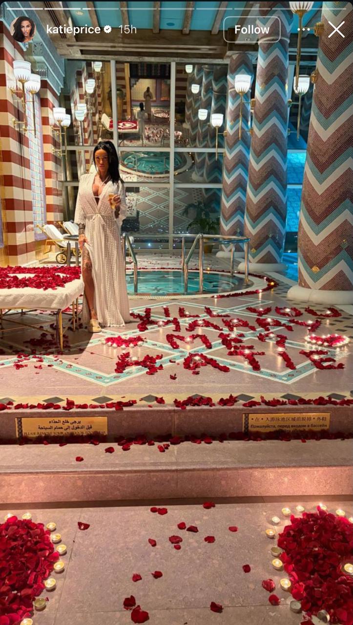 Katie Price pulled out all the stops for romance, posing inside a luxury Dubai hotel suite where rose petals and flickering candlelight spelled out