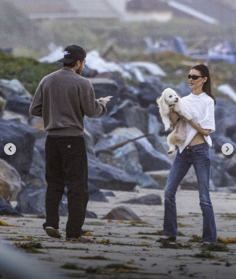 Brooklyn Peltz Beckham gestures towards Nicola Peltz Beckham as she poses with their dog during their beach outing in Malibu. The couple appeared relaxed and in good spirits throughout the 30-minute walk. | Source: Instagram/dailymailuk