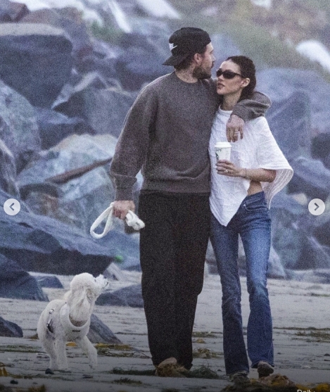 Brooklyn Peltz Beckham and Nicola Peltz Beckham share a quiet moment as they walk arm in arm along the beach, with their dog trotting beside them. The couple appeared united and affectionate throughout the outing. | Source: Instagram/dailymailuk