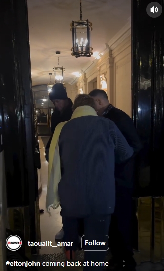 Escorted into his building, Sir Elton John is seen from behind as he heads indoors after the tense moment outside. | Source: Instagram/taoualit__amar