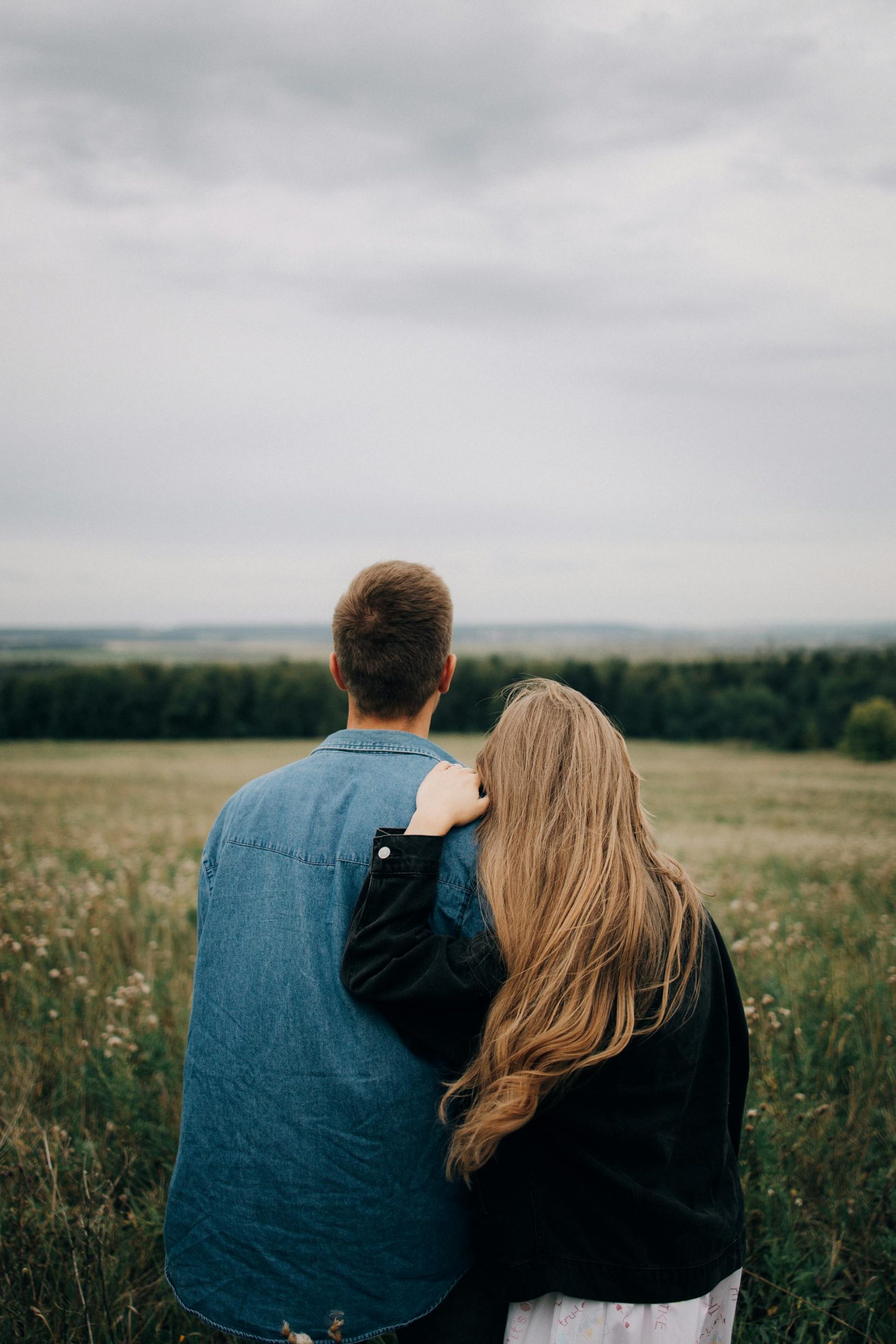 A back view of a couple looking at a field | Source: Pexels