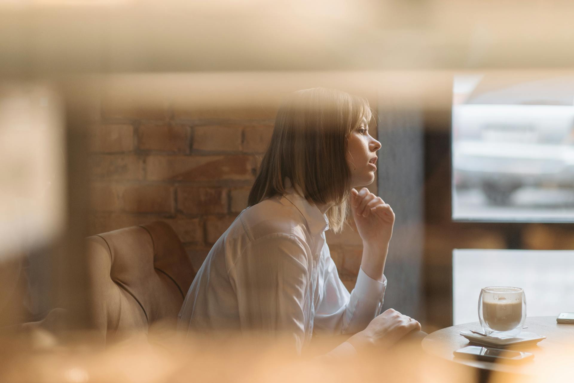 A woman talking to someone while sitting in a coffee shop | Source: Pexels