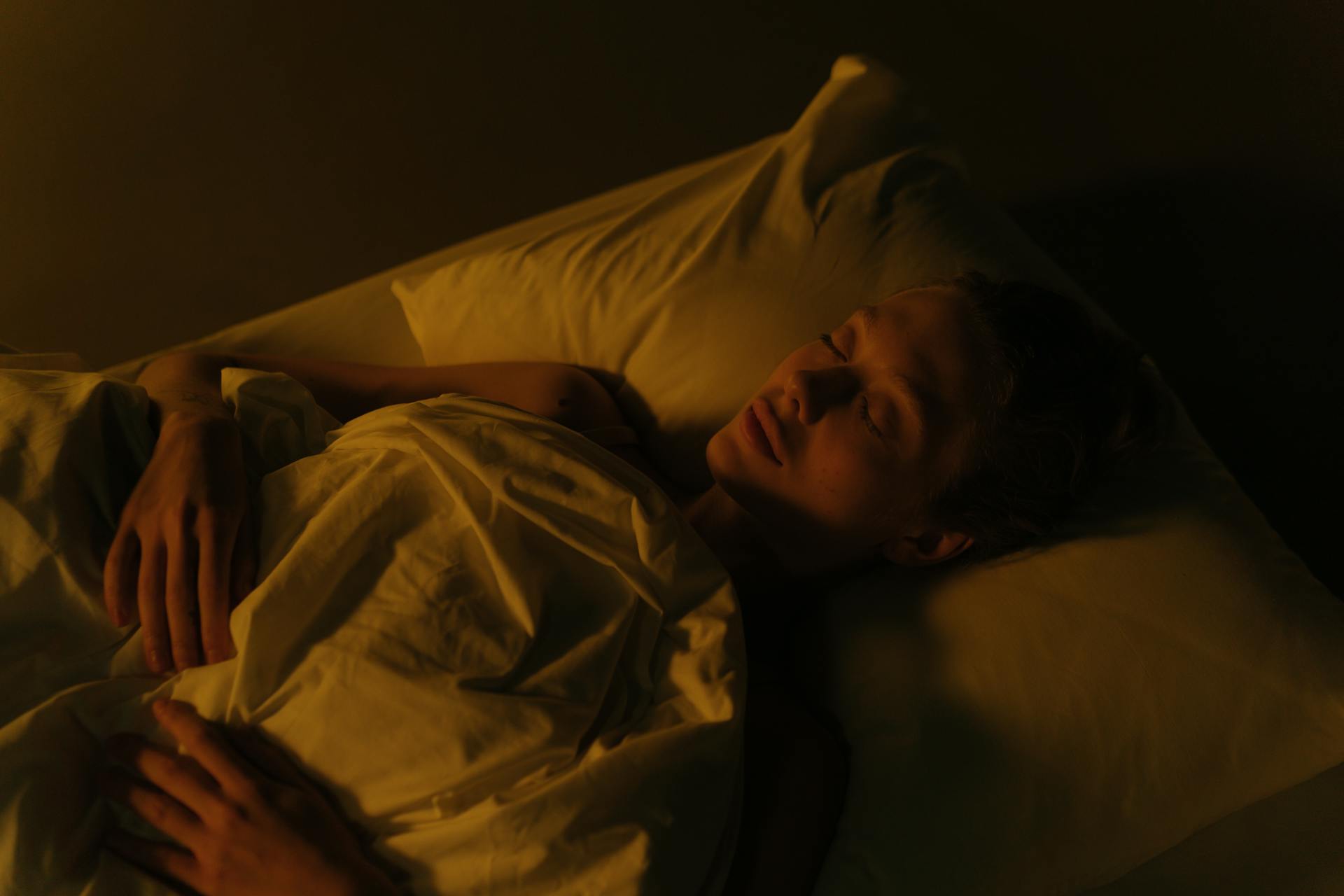 A woman lying in bed at night | Source: Pexels