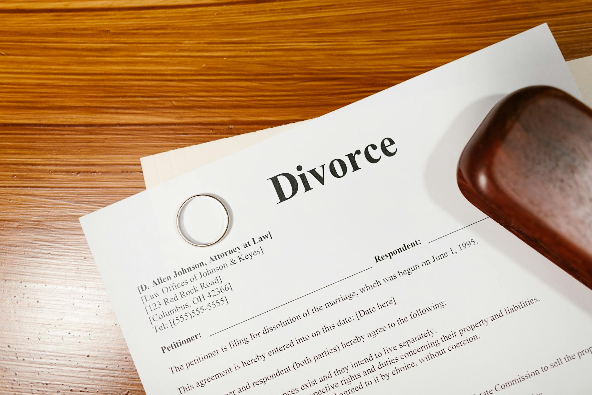 Divorce papers and a wedding ring lying on a wooden surface | Source: Pexels