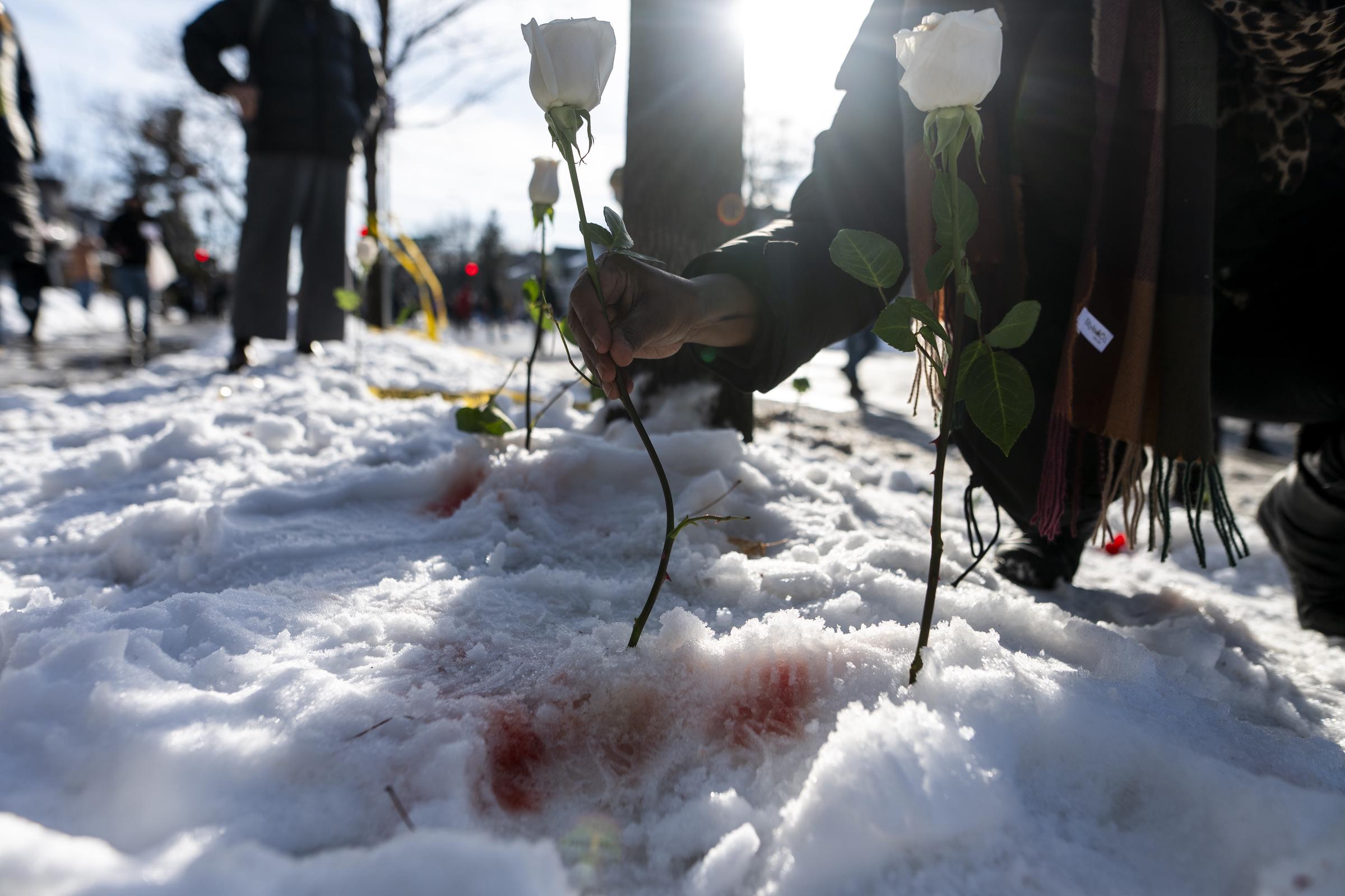 A person places a white rose at the scene where a woman was shot and killed by an ICE agent in Minneapolis on January 7, 2026 | Source: Getty Images