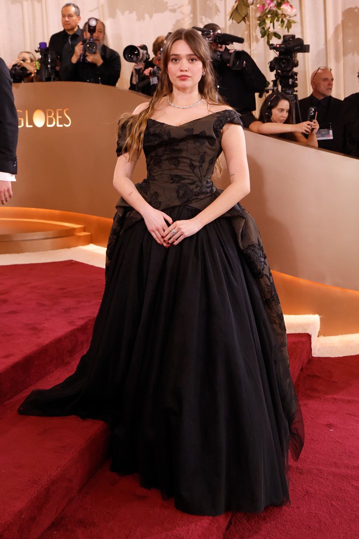 Aimee Lou Wood Stuns in Dramatic Black and Floral Detail: Aimee Lou Wood lit up the red carpet in a flowing black gown adorned with delicate floral embroidery, bringing a touch of vintage romance to the night. With its sweeping silhouette and graceful lines, the look captured the very essence of Golden Age glamour.