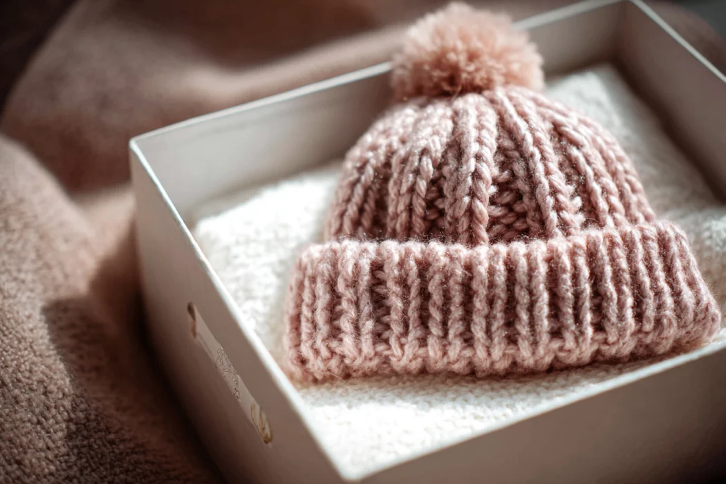 A hand-knit cap for a baby girl | Source: Midjourney