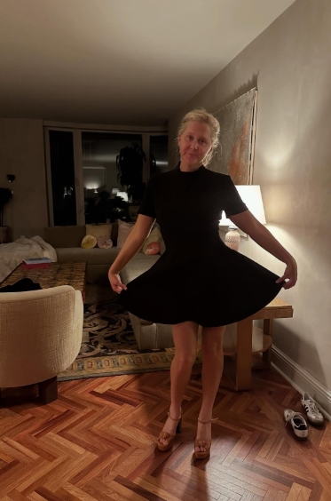 In a short black dress and tan heels, Amy Schumer struck a playful pose, lifting the hem to show off her slim legs and noticeably trimmer frame. The natural lighting and unedited setting gave an authentic look at her post-weight-loss confidence. | Source: Instagram/amyschumer