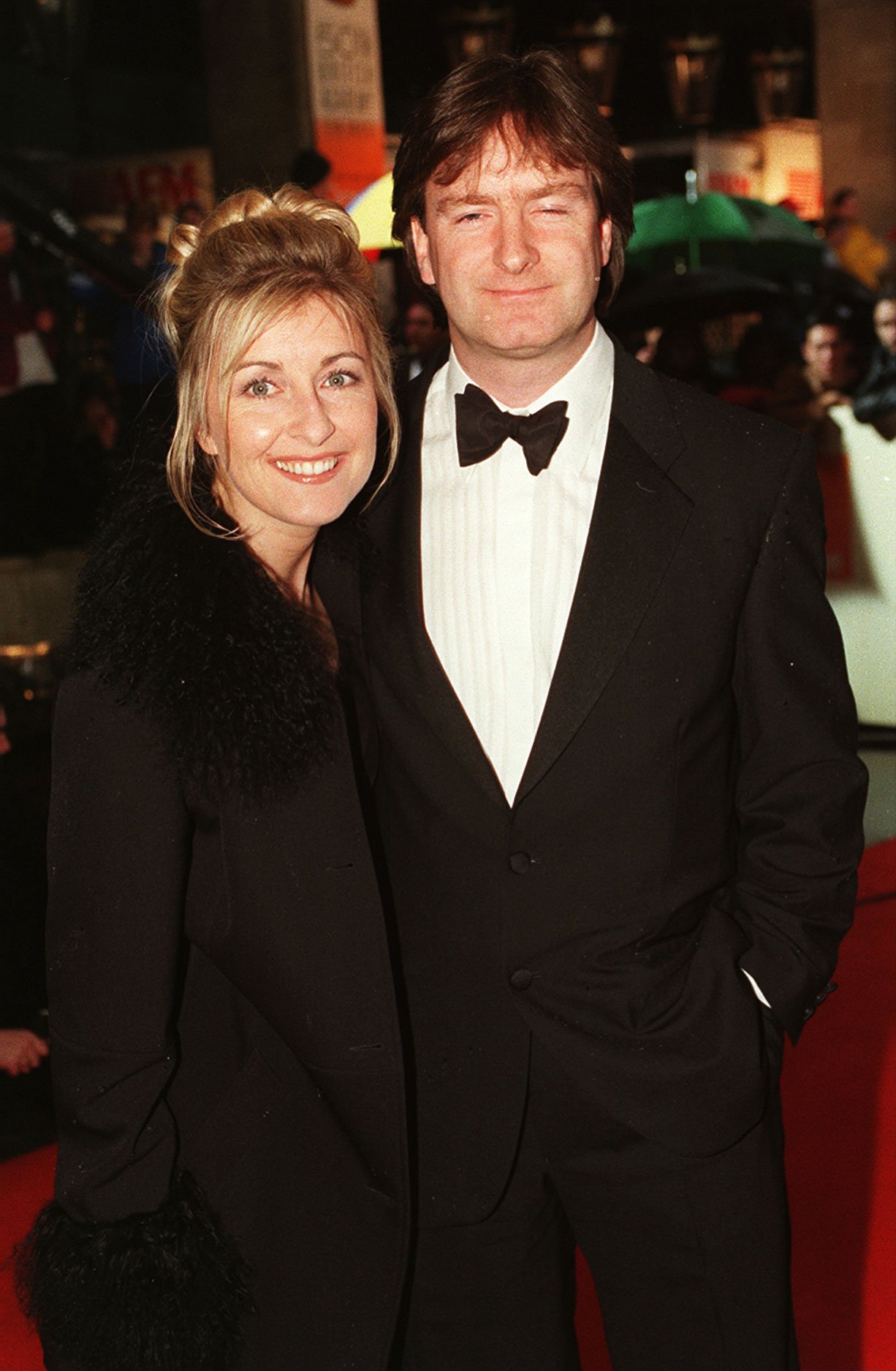 Fiona Phillips and her husband, Martin Frizell, arrived at the 50th BAFTA Awards at the Grosvenor House Hotel in London, England, on April 19, 1998, photographed during a period when Phillips was a prominent television presenter and the couple were familiar figures on the red carpet, long before her Alzheimer's diagnosis reshaped their private lives.