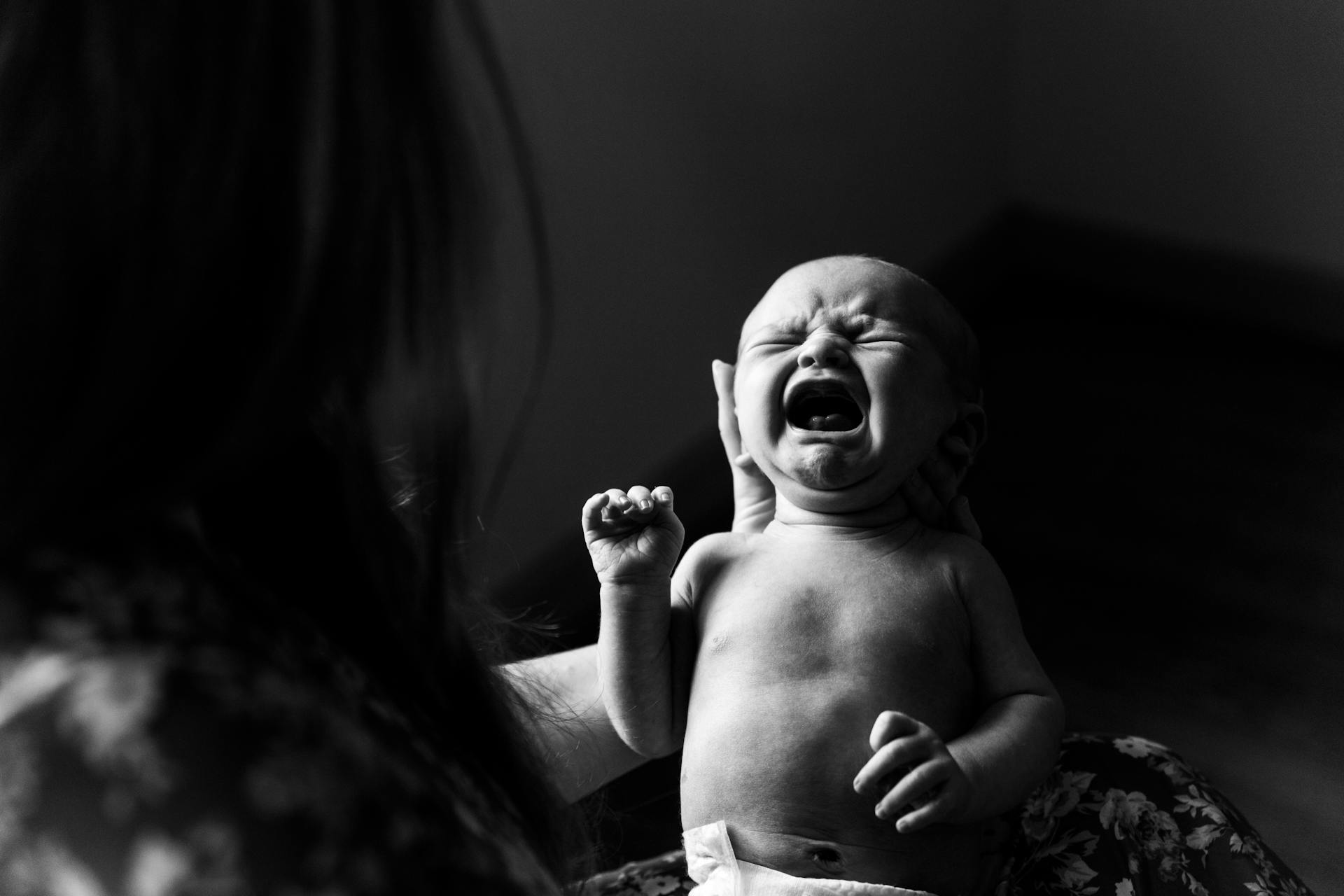 A person holding a crying newborn baby | Source: Pexels