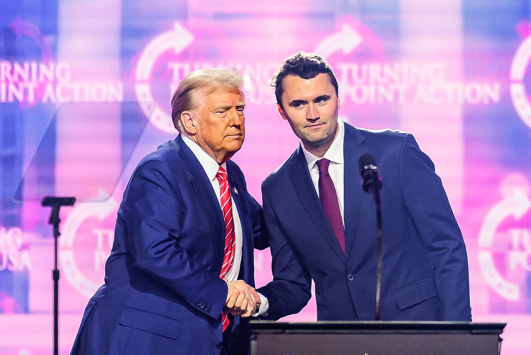 Charlie Kirk speaks on stage with President Donald Trump at America Fest in Phoenix, Arizona, on December 22, 2024 | Source: Getty Images